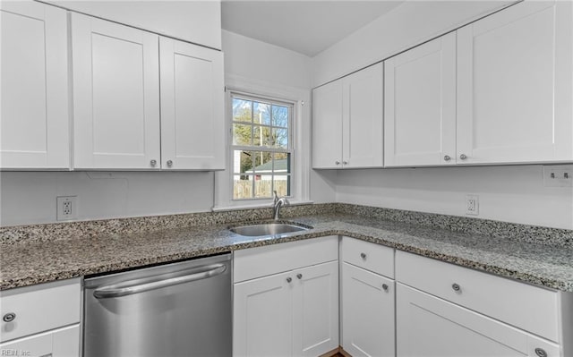 kitchen featuring dishwasher, white cabinets, light stone counters, and sink