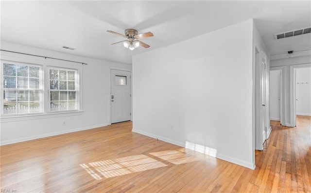 empty room with ceiling fan and light hardwood / wood-style flooring