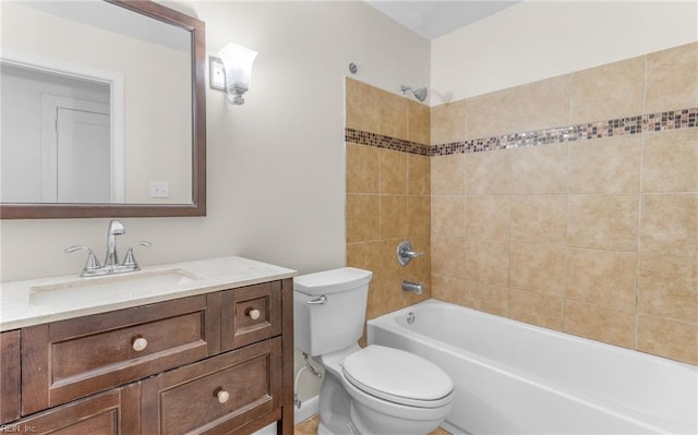 full bathroom featuring vanity, tiled shower / bath, and toilet