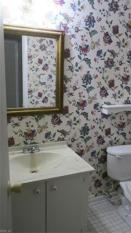 bathroom with tile patterned flooring, vanity, and toilet