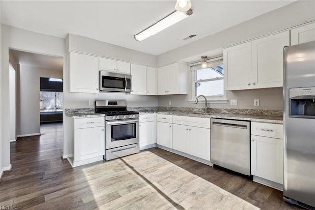 kitchen featuring dark hardwood / wood-style floors, white cabinetry, and appliances with stainless steel finishes