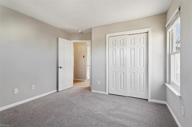 unfurnished bedroom featuring light colored carpet, multiple windows, and a closet