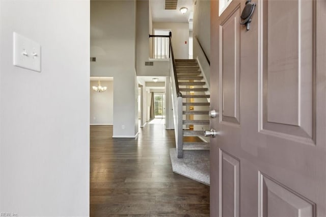 foyer with dark hardwood / wood-style floors and an inviting chandelier