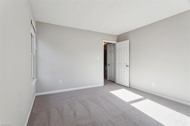 carpeted empty room with a textured ceiling