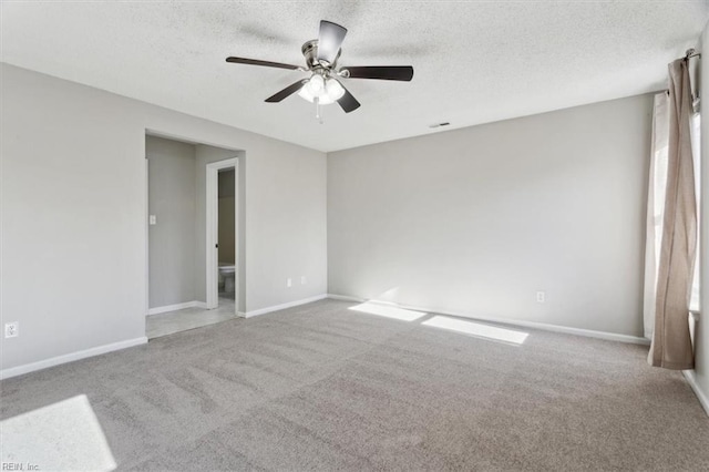 carpeted spare room with ceiling fan and a textured ceiling