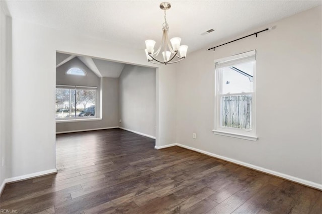 unfurnished dining area with a chandelier, dark hardwood / wood-style floors, and lofted ceiling