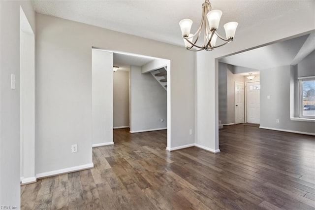 unfurnished dining area with a notable chandelier and dark wood-type flooring