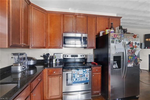 kitchen featuring dark stone counters, dark wood-type flooring, stainless steel appliances, and sink