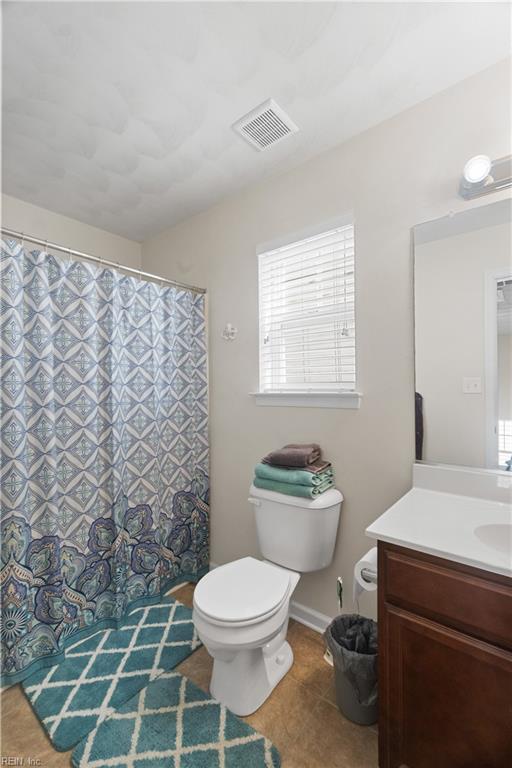 bathroom featuring tile patterned floors, vanity, and toilet