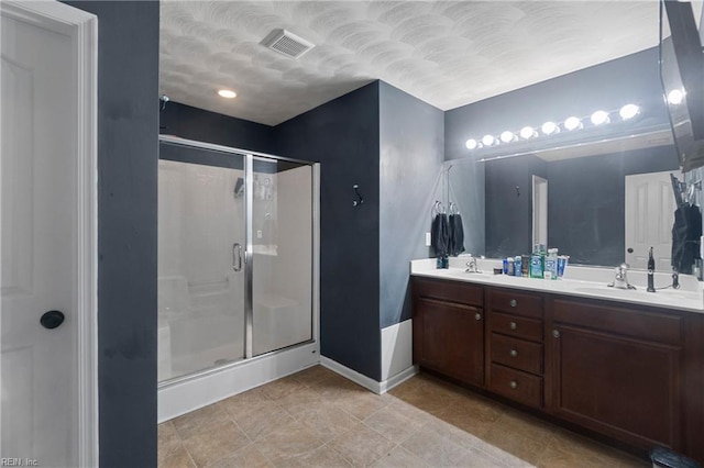 bathroom with tile patterned flooring, vanity, and an enclosed shower