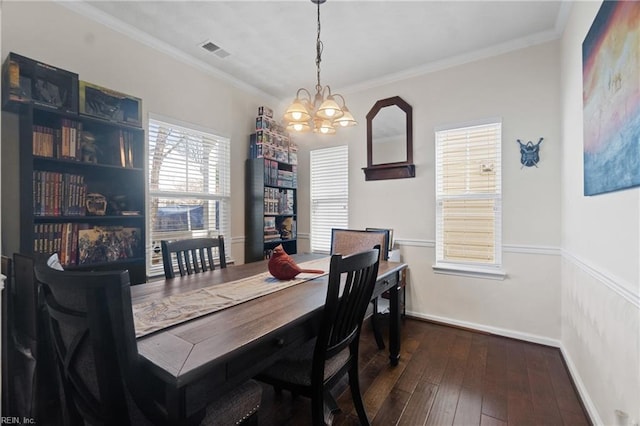 dining space featuring dark hardwood / wood-style floors, an inviting chandelier, and crown molding