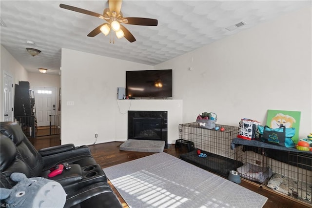 living room with ceiling fan and dark wood-type flooring