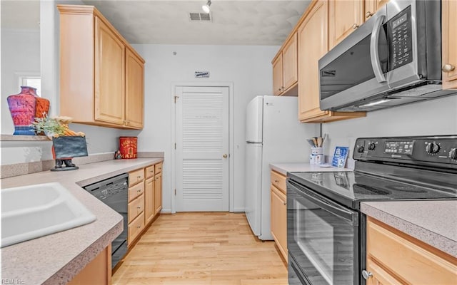 kitchen with light brown cabinetry, sink, light hardwood / wood-style floors, and black appliances