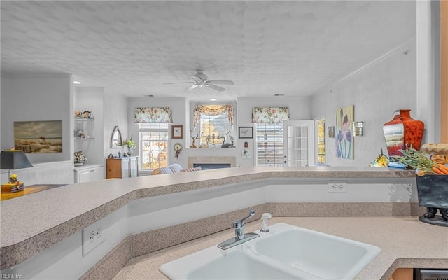 kitchen featuring a textured ceiling, ceiling fan, and sink