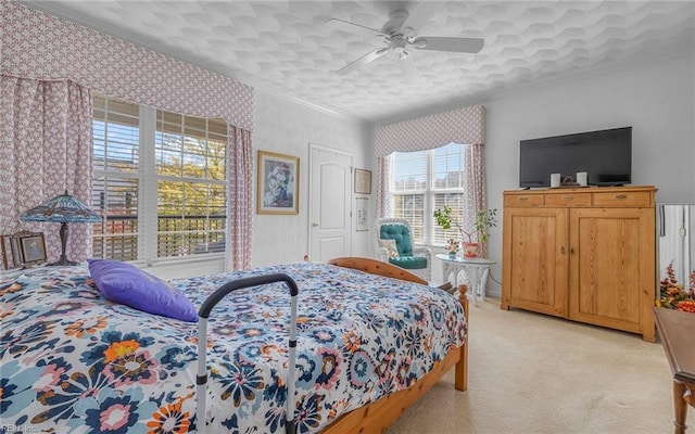 carpeted bedroom with ceiling fan and ornamental molding