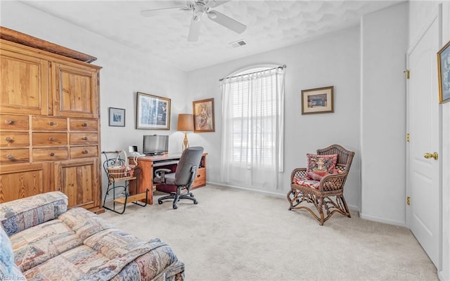 carpeted home office with plenty of natural light and ceiling fan