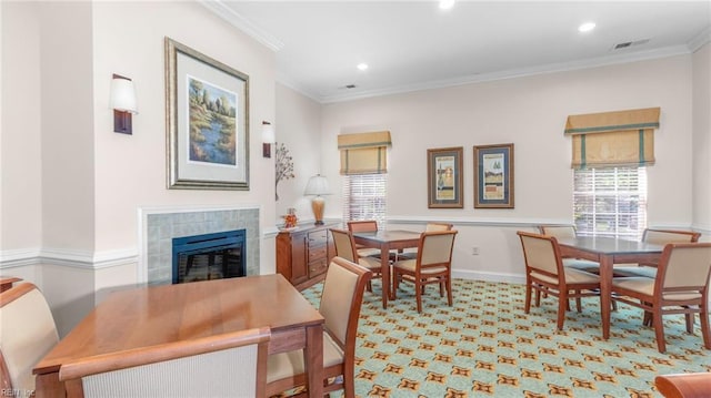 carpeted dining room with crown molding and a fireplace