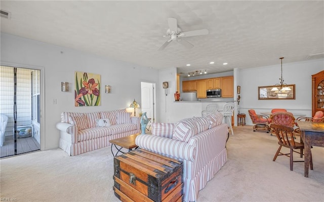 living room with ceiling fan, light colored carpet, and a textured ceiling