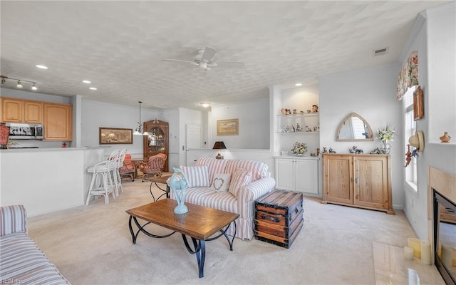 carpeted living room featuring ceiling fan and a textured ceiling