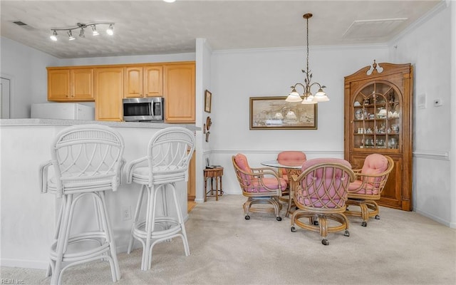 dining space with light carpet, crown molding, and a chandelier