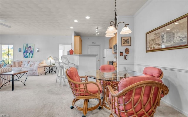 dining area with a textured ceiling, ceiling fan with notable chandelier, light colored carpet, and crown molding