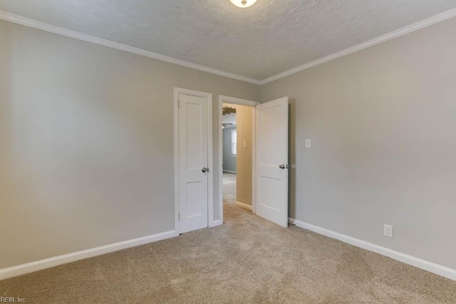 unfurnished room featuring a textured ceiling, crown molding, and light carpet