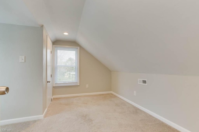 bonus room featuring light carpet and vaulted ceiling