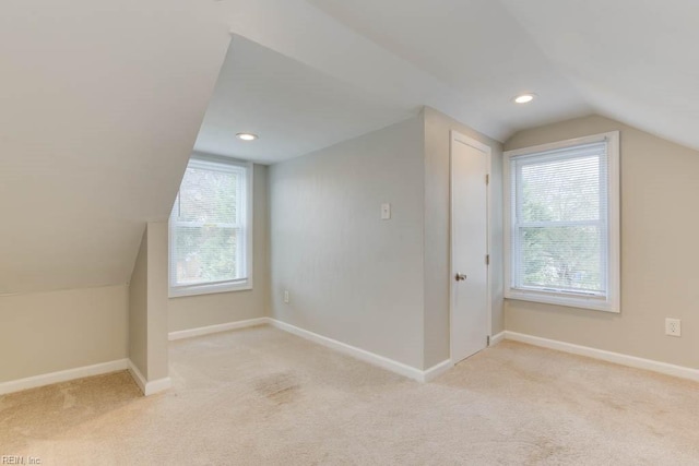 bonus room with light colored carpet and lofted ceiling