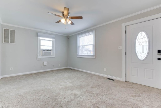 carpeted foyer entrance featuring a healthy amount of sunlight and ornamental molding