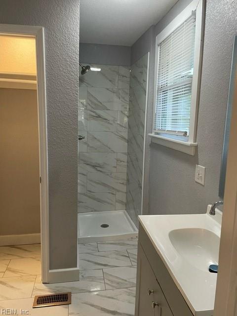 bathroom featuring vanity and tiled shower