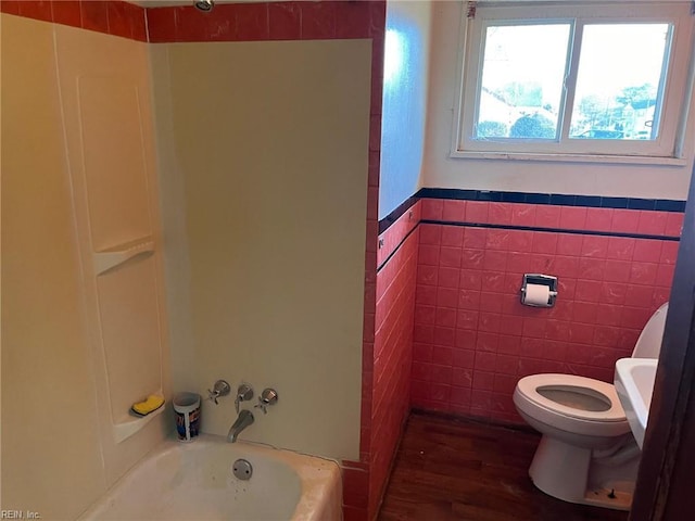 bathroom with toilet, tile walls, and  shower combination