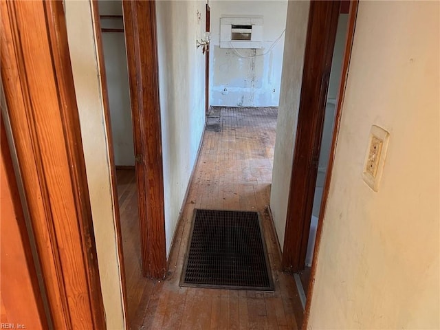 hall with hardwood / wood-style floors and an AC wall unit