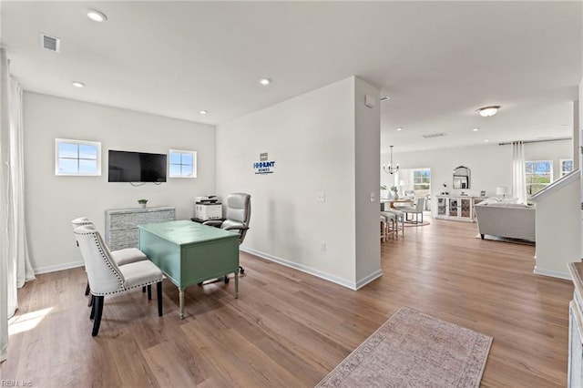 dining space with light wood-type flooring and a notable chandelier