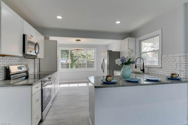 kitchen with white cabinets, plenty of natural light, and appliances with stainless steel finishes