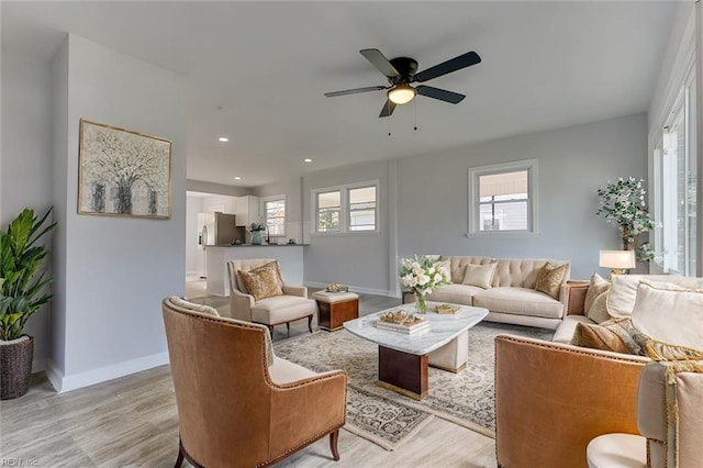 living room with light hardwood / wood-style flooring and ceiling fan