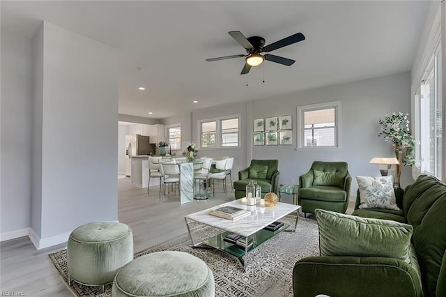 living room with ceiling fan and light hardwood / wood-style flooring