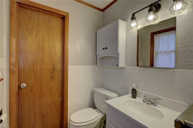 bathroom with vanity, crown molding, decorative backsplash, toilet, and tile walls