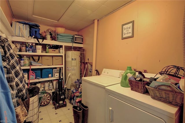 washroom with washing machine and clothes dryer and water heater