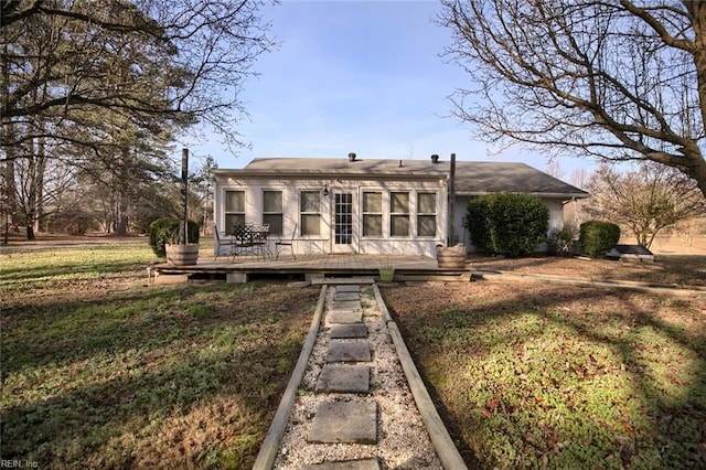 rear view of house with a yard and a deck