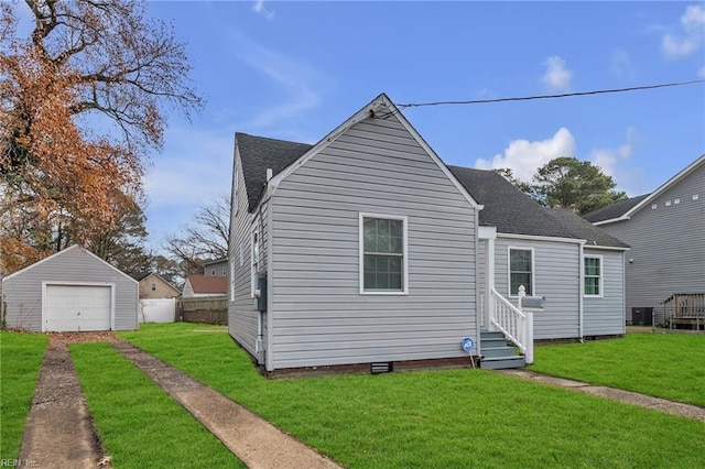 view of front of house featuring a garage, an outbuilding, a front yard, and central AC