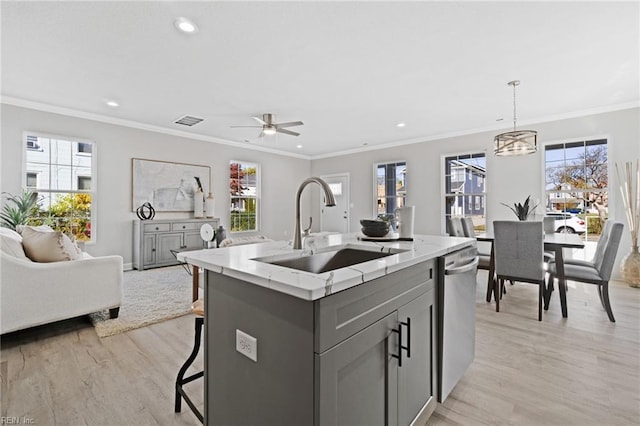 kitchen with dishwasher, decorative light fixtures, gray cabinets, and a center island with sink