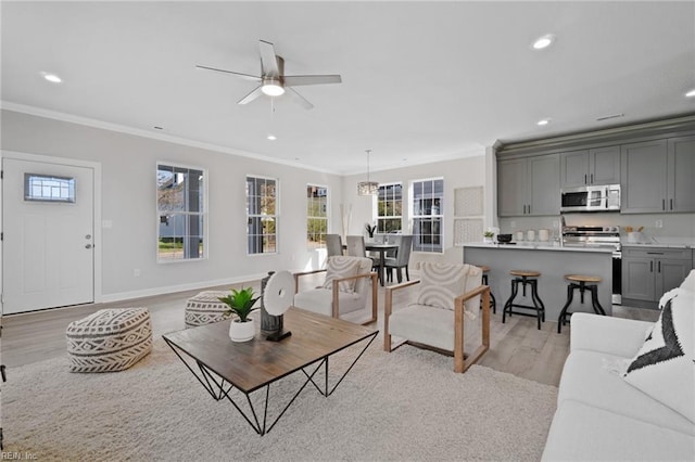 living room featuring crown molding, ceiling fan, and light hardwood / wood-style floors