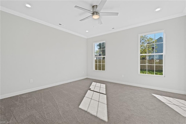 carpeted spare room with a wealth of natural light, ceiling fan, and ornamental molding