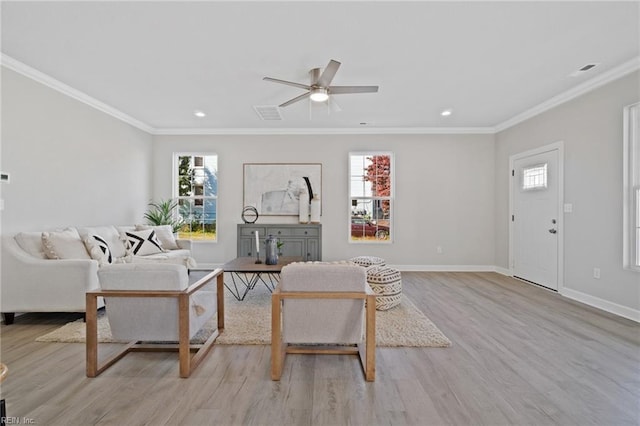 living room featuring plenty of natural light, ceiling fan, ornamental molding, and light hardwood / wood-style flooring