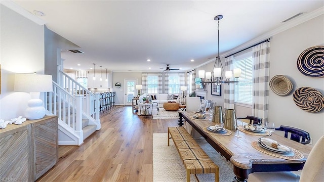 dining area with stairway, visible vents, a chandelier, and light wood finished floors