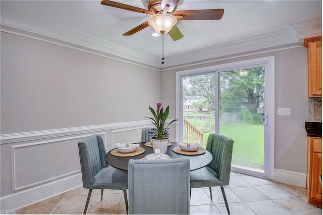 tiled dining area with crown molding and ceiling fan