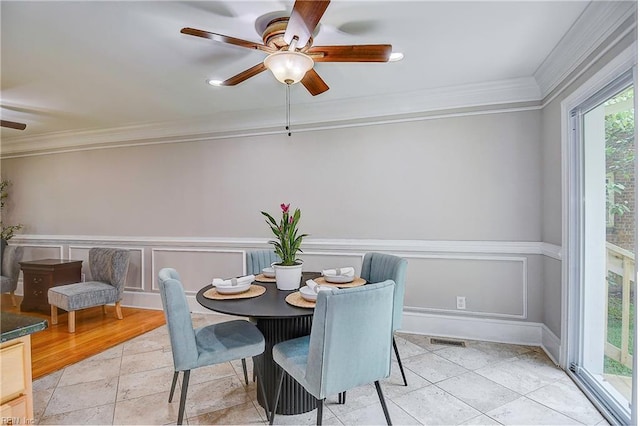 dining area featuring ceiling fan, ornamental molding, and light tile patterned floors