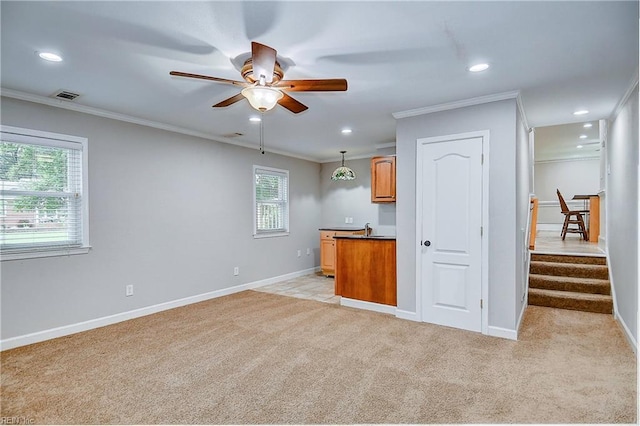 interior space with light colored carpet, crown molding, and a wealth of natural light