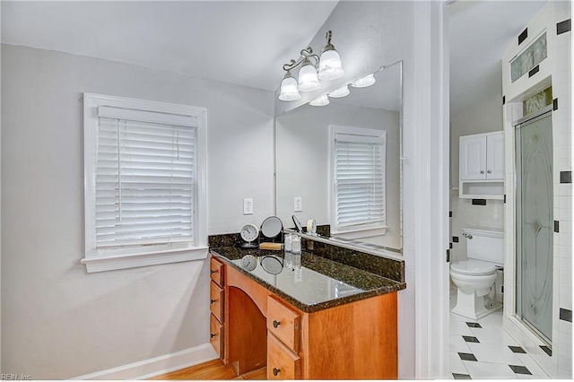 bathroom featuring a shower with door, vanity, a chandelier, and toilet