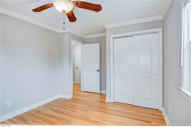 unfurnished bedroom featuring ceiling fan, a closet, crown molding, and light hardwood / wood-style floors